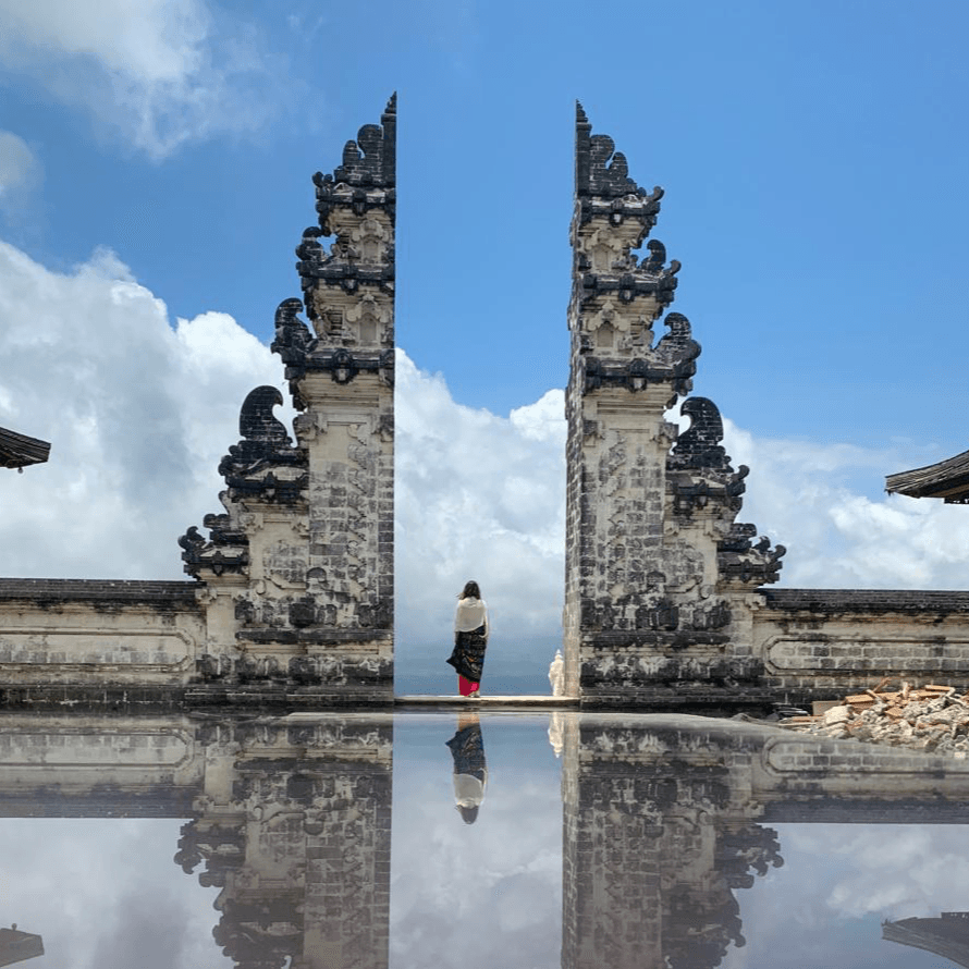 Bali temple gate opening toward tropical sky