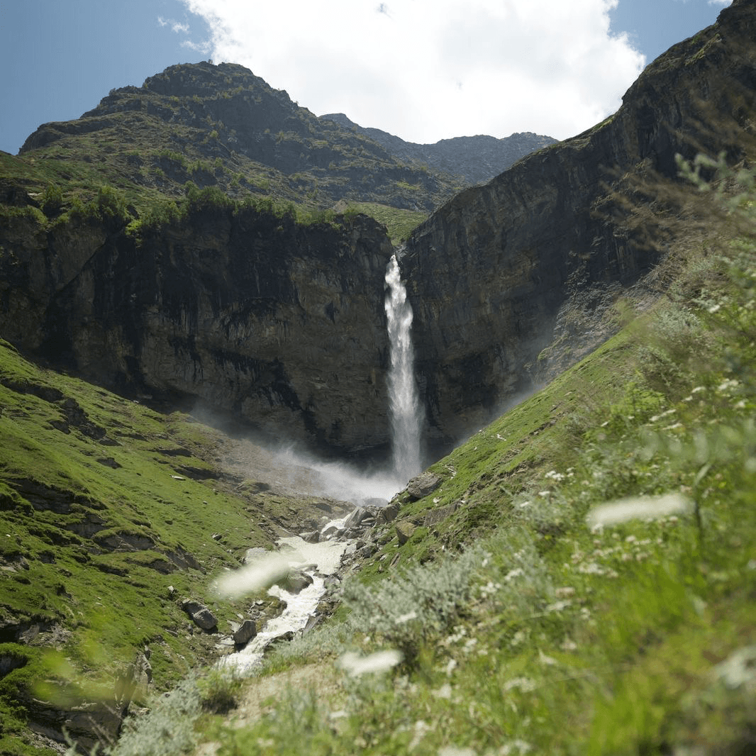 Manali Sissu waterfall valley surrounded by steep green slopes